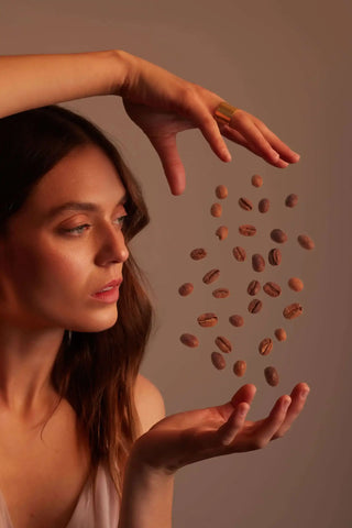 Woman playing with coffee beans in her hands.